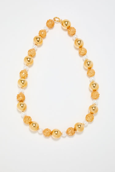 Gold sculptural necklace with white pearl detail